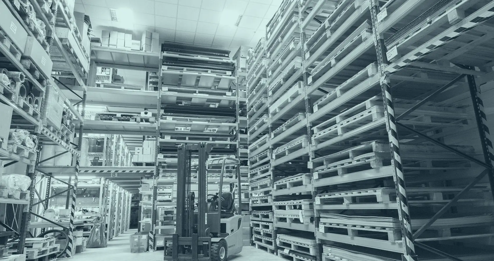 Pasillo de un depósito mayorista con estanterías altas cargadas de pallets y cajas